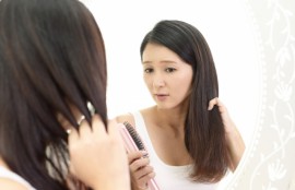 髪の毛を鏡で見る女性